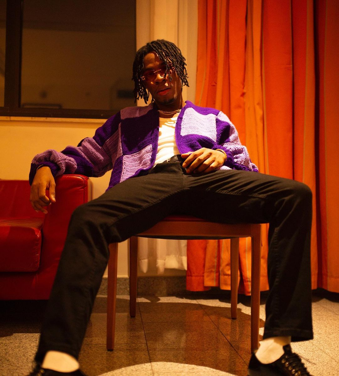 Joeboy sitting on chair